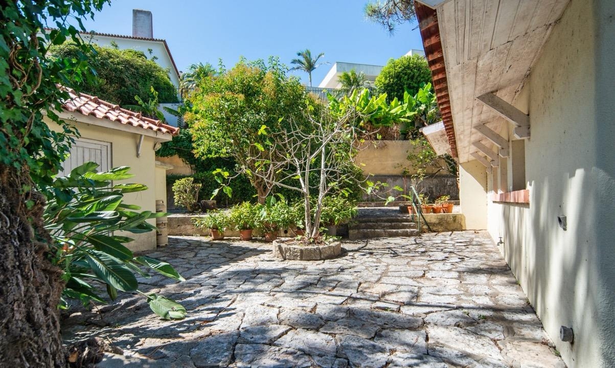 Pátio empedrado e jardim ao lado da casa