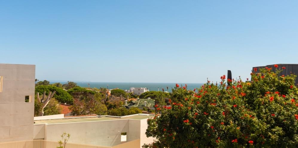 Vista de mar sobre os telhados e pinheiros do Estoril
